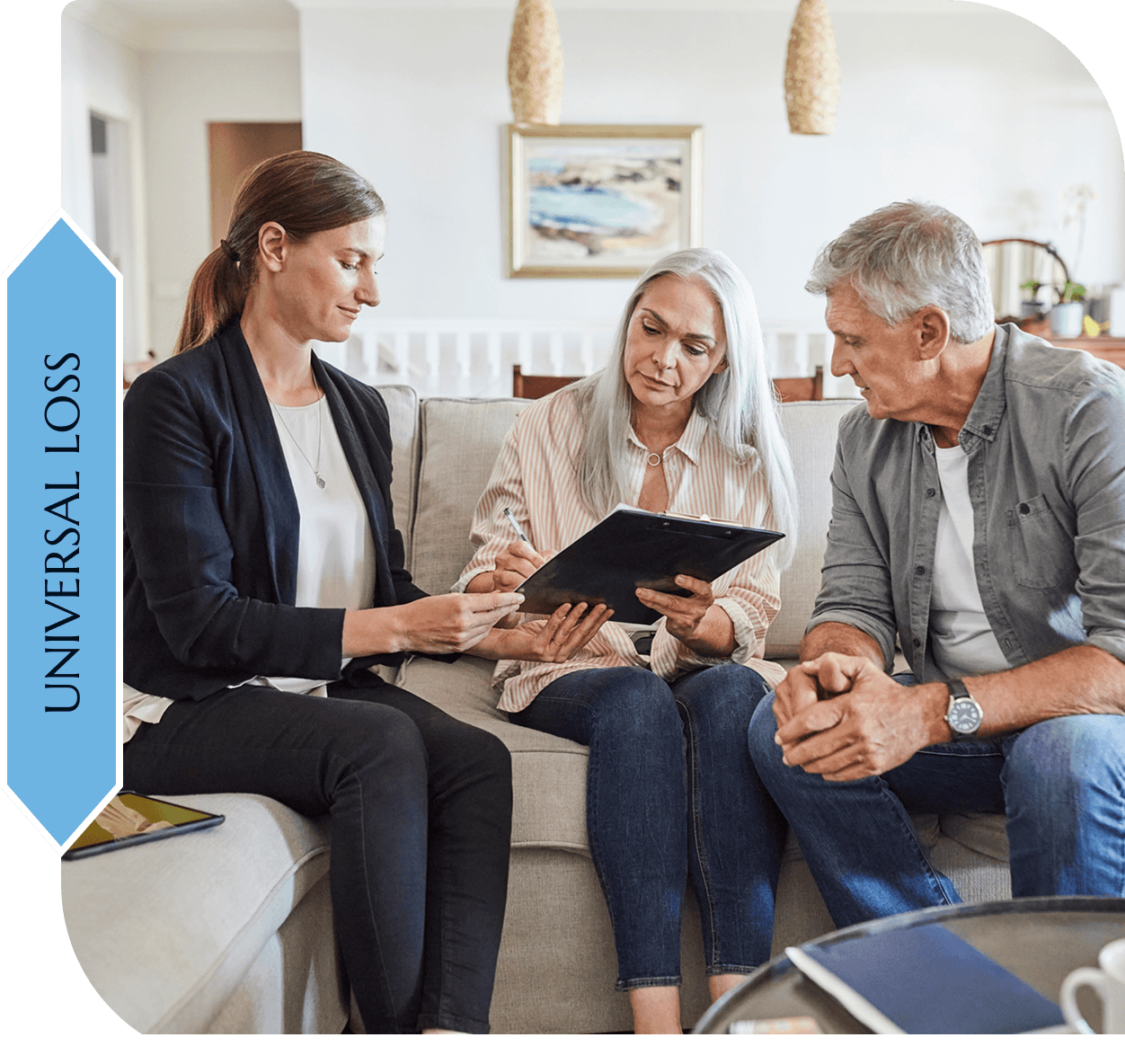Three people discussing documents on sofa.